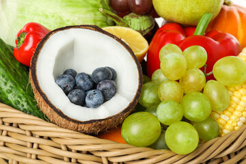 Different fresh vegetables and fruits in wicker basket, closeup