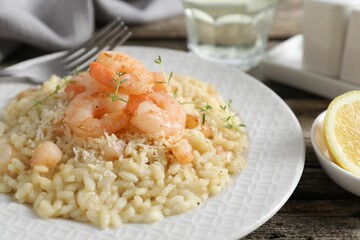 Delicious risotto with shrimps and cheese on wooden table, closeup