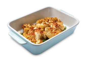 Delicious baked cauliflower steaks with garlic and parsley in baking dish isolated on white