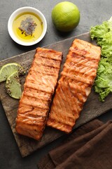 Delicious grilled salmon fillets served on grey table, flat lay