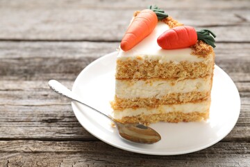 Piece of delicious carrot cake on wooden table, closeup