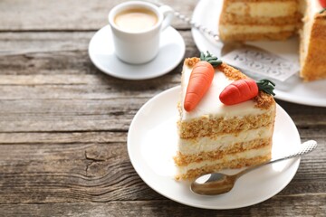 Piece of delicious carrot cake served with coffee on wooden table, closeup. Space for text