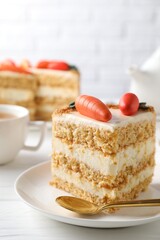 Piece of delicious carrot cake on white wooden table, closeup