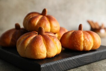 Tasty pumpkin shaped buns on grey table, closeup