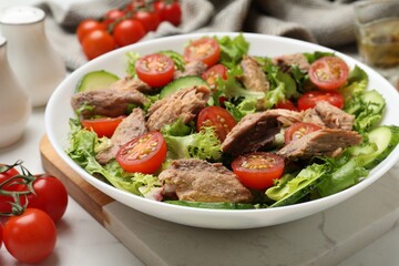 Delicious fresh tuna salad on white table, closeup
