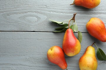 Ripe juicy pears on grey wooden table, flat lay. Space for text