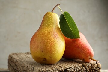 Ripe juicy pears on table against grey background, closeup