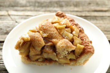 Slice of homemade apple pie on wooden table, closeup