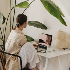 Modern Home Office Aesthetic with Woman, Laptop, and Large Indoor Plant