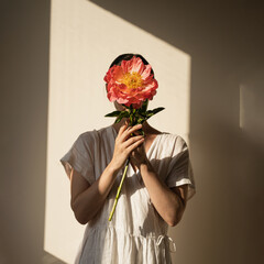 Woman in White Dress Holding Large Flower. Face Hidden, Soft Shadow, Minimalistic Aesthetic, Natural Light, Artistic Composition