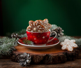 Festive Christmas, New Year composition with gingerbread cookies the red cup and fir tree branches.