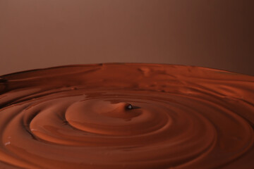 Delicious melted chocolate on brown background, closeup