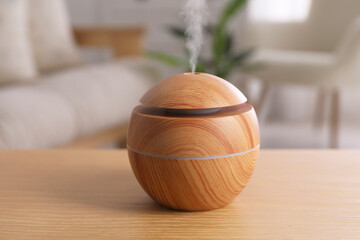 Essential oil diffuser on wooden table at home