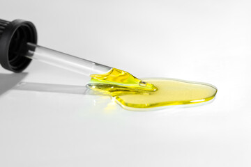 Cosmetic oil and pipette on light grey background, closeup