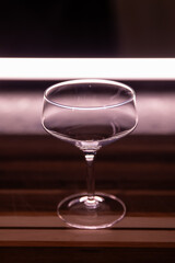 empty angled crystal coupe cocktail glass on wooden cutting board