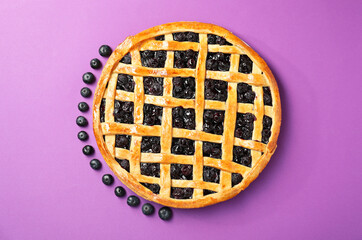 Tasty homemade pie with blueberries on purple table, top view