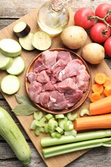 Cooking stew. Uncooked meat and vegetables on wooden table, top view