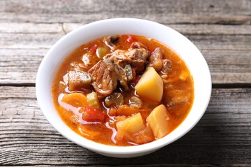 Delicious stew with vegetables in bowl on wooden table, closeup