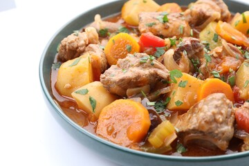 Delicious stew with vegetables isolated on white