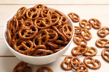 Tasty pretzel crackers on light wooden table, closeup