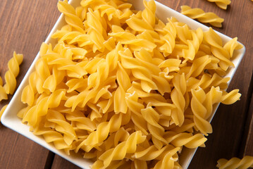 Primo piano di fusilli crudi, classico formato di pasta italiana, gastronomia europea 