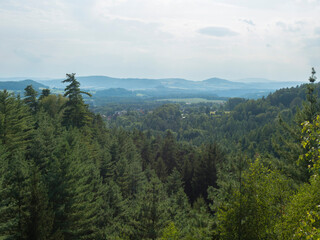 Panoramic view from sandstone rock viewpoint Ponorka, submarine at the top of 3 sandstone towers near Ceska Kamenice town. Summer landscape in Lusatian Mountains, green hills,oak and pine tree forest.
