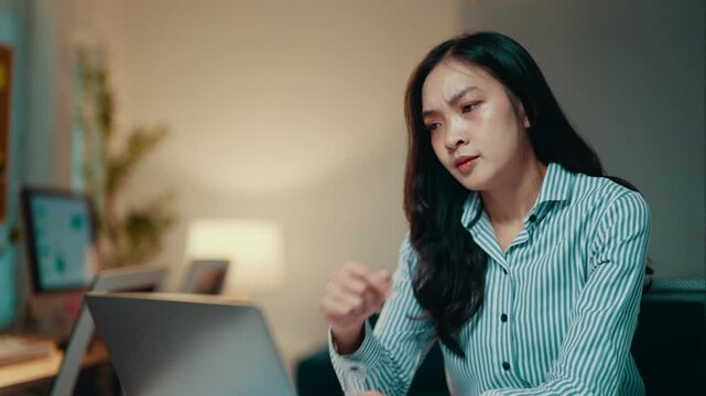 Businesswoman struggling with an increasing headache while working on a laptop in the office. Stress and pressure from deadlines contribute to feelings of frustration and exhaustion