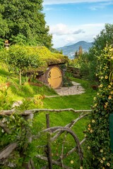 beautiful green burrowed home for hobbits in central american nature landscape with a yellow door during the day