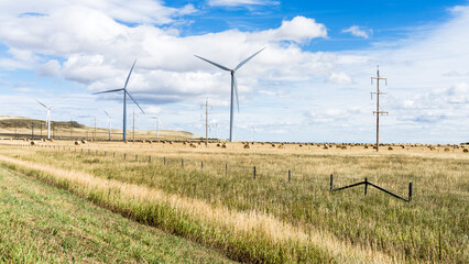 Wind power towers on  agricultural field  with bales of hay at fall season