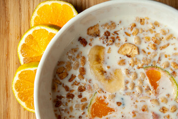 A nourishing oat meal breakfast mixed with milk, topped with juicy tangerine slices and sweet banana.