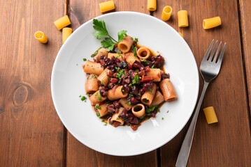 Piatto di pasta con ragù di polpo, cibo italiano, cucina mediterranea 