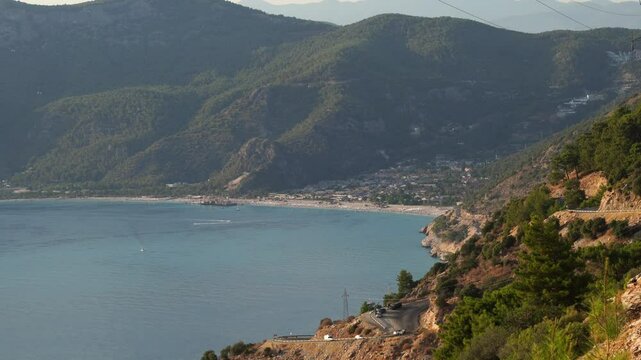Traffic on the winding butterfly valley road with a view of oludeniz in the background, Fethiye, Mugla, Turkey
