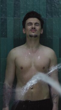 Shot back man have anti-cellulite treatment experiencing douche. Hands of nurse regulate Charcot douche equipment at spa center. Water massage. Slow motion