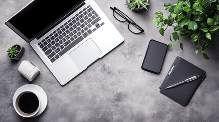 A flat lay image of a work desk with a laptop, coffee cup, and other office supplies.