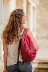 College or university student walks with her backpack and books around the campus. Learning new knowledge. Education is a right for all people.