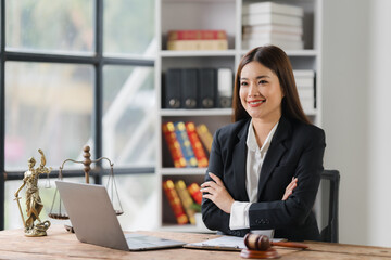 Confident Legal Professional:  A smiling female lawyer confidently sits at her desk in a modern office, showcasing a professional and approachable demeanor.  She exudes confidence and expertise.