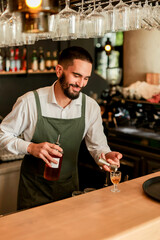 Skilled bartender prepares a cocktail at a stylish bar during a vibrant evening in a bustling city