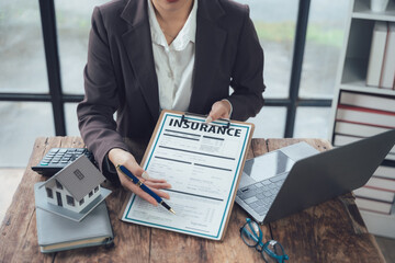 Insurance Agent Consulting Client:  A detail-oriented insurance agent meticulously reviews policy...