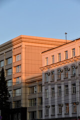 Fototapeta premium The yellow facade of the building in the evening sun. The walls of a house in the city in summer. Government buildings.