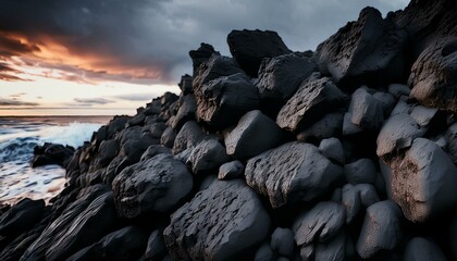 Dark rocks on a beach at sunset