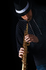 soprano saxophone in the hands of a guy on a black background