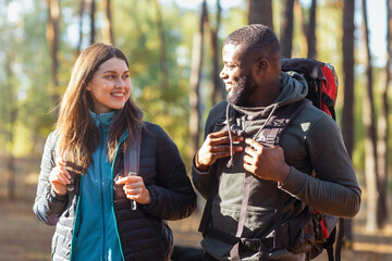 Happy mixed race couple looking at each other under sunset lights, having magic moments while...