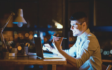 Smiling Businessman Using Voice Assistant Holding Cellphone Sitting At Laptop In Modern Office At Night. Low Light