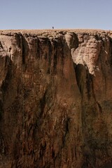 Hiker traversing rocky mountainside cliff edge