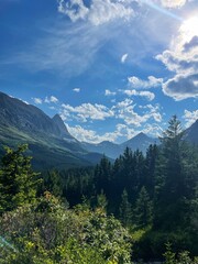 Golden sunset illuminates a serene river winding through rugged mountains and lush forest.