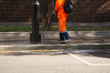 Cleaning of footpaths by a utility worker using water and shampoo