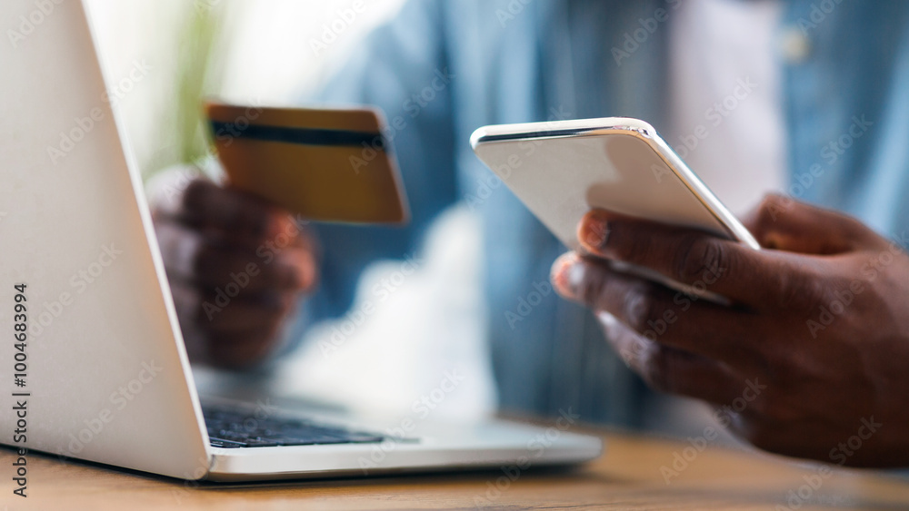 Aufkleber online payment. unrecognizable black man holding credit card and using smartphone for shopping in in