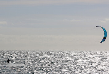 Naklejka premium Kitesurfer riding his board in waves 