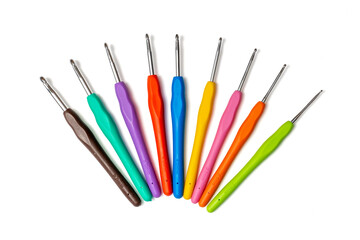 set of colorful metal crochet hooks with plastic handles in fan shape on white background
