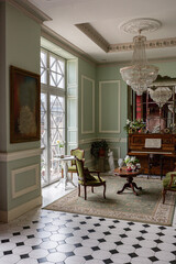 the chic expensive interior of the living room in the historical Baroque style, tiles on the floor, walls decorated with wood. the furniture is in a historical style.
